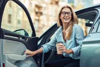 femme qui sort de la voiture avec un café