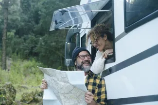 couple qui regarde une carte par la fenêtre de leur camping car