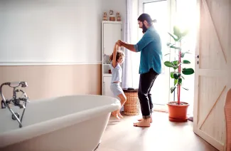 pere et fille qui dansent dans une salle de bain