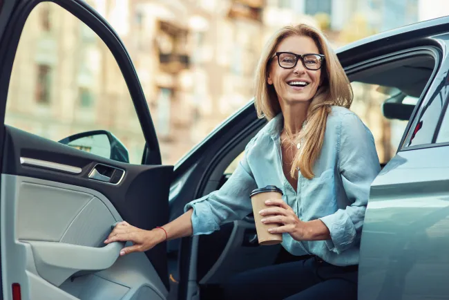 femme qui sort de la voiture avec un café