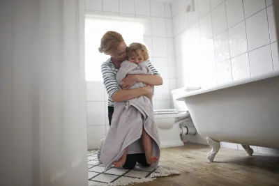 maman qui essuie son enfant qui sort de la douche