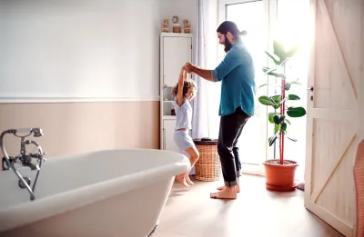pere et fille qui dansent dans une salle de bain